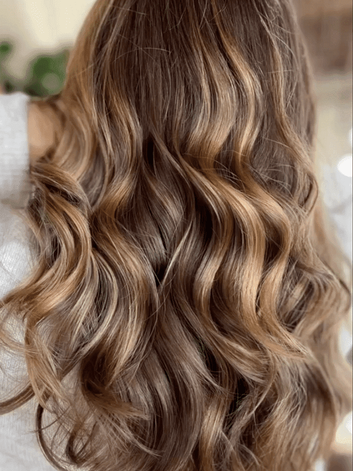 Close-up of wavy brown hair with blonde highlights.